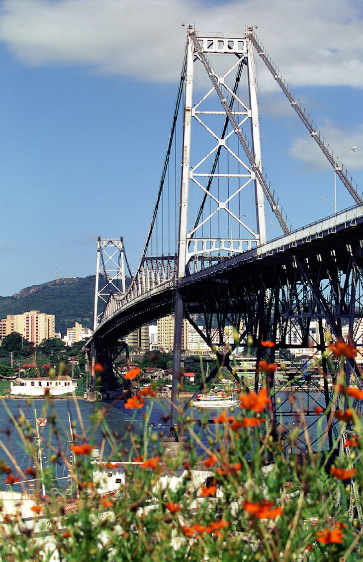 Ponte Hercilio Luz - É uma das maiores pontes pênseis do mundo. Construída em 1926 pela firma Buington & Sundstrom, esta ponte tornou-se o cartão-postal de Florianópolis. Foi a primeira ligação entre a Ilha de Santa Catarina e o continente. A construção da ponte foi o evento decisivo que firmou Florianópolis como Capital do Estado de Santa Catarina. Florianopolis (SC). 1999. Foto:  Christian Knepper / Embratur 