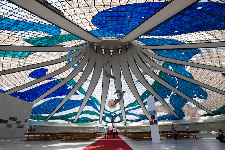 Anjos Suspensos de Alfredo Ceschiatti no interior da Catedral Metropolitana de Brasilia. Entre as obras do arquiteto Oscar Niemeyer, a considerada mais bela pelos brasilienses é a Catedral Metropolitana de Brasília, localizada na Esplanada dos Ministérios. Foi inaugurada em 1967 e tombada pelo então Departamento de Patrimônio Histórico e Artístico Nacional. Possui 40 m de altura com 16 arcos de concreto armado circundado por um espelho d’água. No topo do templo, há uma cruz metálica, abençoada pelo Papa Paulo VI, e que incorpora um fragmento da cruz de Cristo. Brasília (DF). Foto: Beto Garavello/ LUME