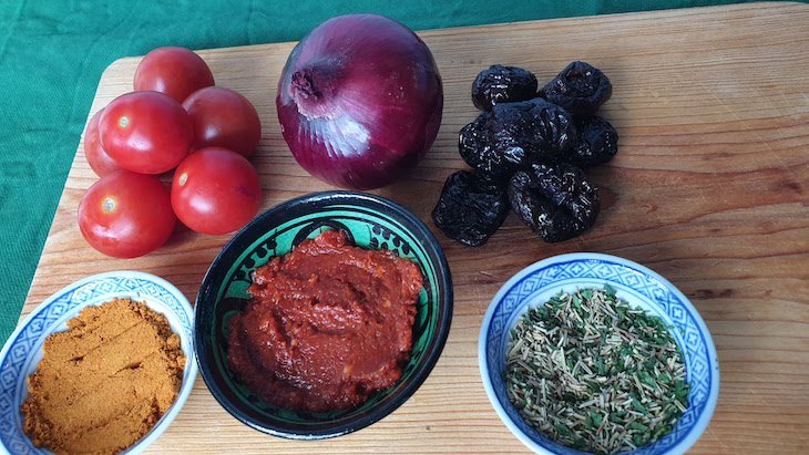 Da esquerda para a direita: tomate cherry, cebola roxa, ameixas; especiarias de Marrocos, harissa e alecrim seco. Receita de coelho assado no forno, com especiarias de Marrocos © Viaje Comigo